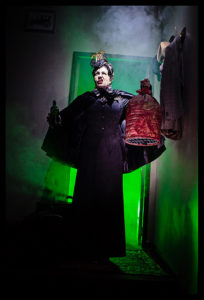 A spooky image of the Wicked Witch standing in a doorway from a theatre performance of Mary Poppins