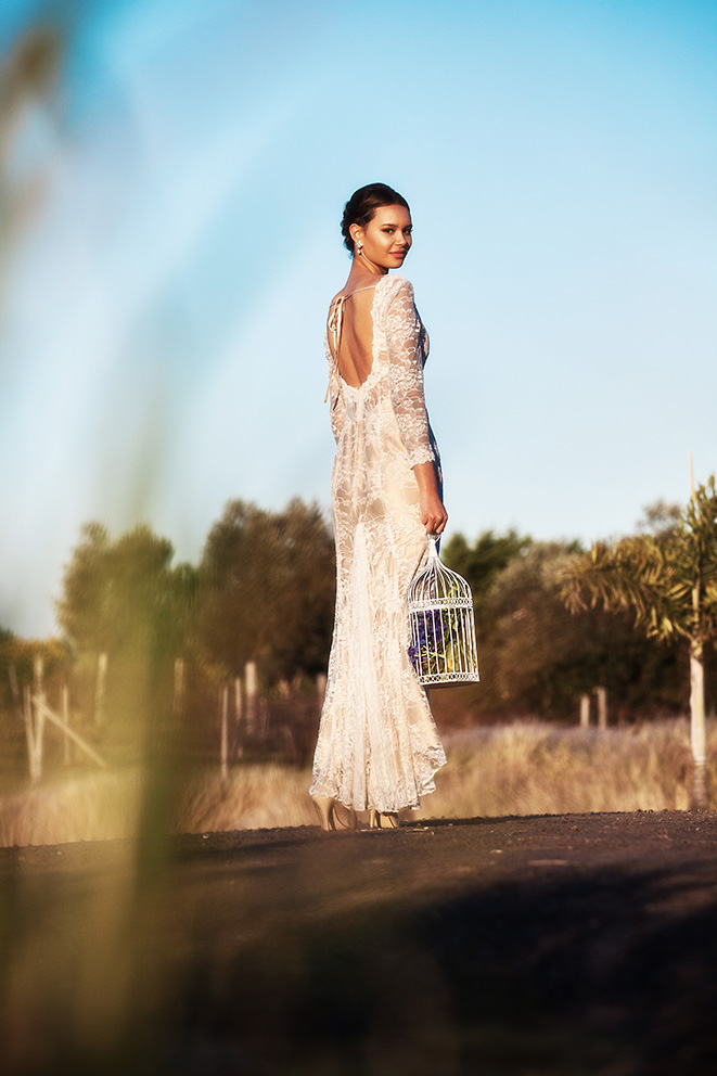 Photo of a bride holding a bird cage wearing her wedding gown designed by Gold Coast Bridal Lounge, Australia.
